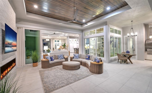 256 Stirling Bridge Dr, Ormond Beach, FL 32174 - living area with a tray ceiling, ceiling fan, a large fireplace, wooden ceiling, and light tile patterned floors