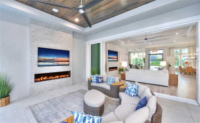256 Stirling Bridge Dr, Ormond Beach, FL 32174 - tiled living room featuring a stone fireplace, ceiling fan, a raised ceiling, and wood ceiling