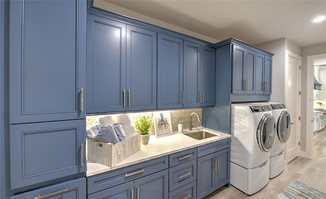 256 Stirling Bridge Dr, Ormond Beach, FL 32174 - laundry area featuring washing machine and dryer, cabinet space, and light wood finished floors