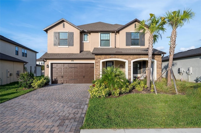 3952 Aldea Way, Wesley Chapel, FL 33543 - view of front of home with decorative driveway, an attached garage, stucco siding, a front lawn, and stone siding