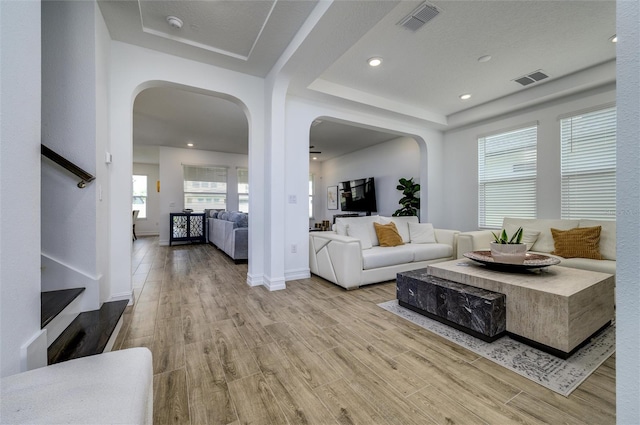 3952 Aldea Way, Wesley Chapel, FL 33543 - living room with arched walkways, wood finished floors, stairway, a raised ceiling, and recessed lighting