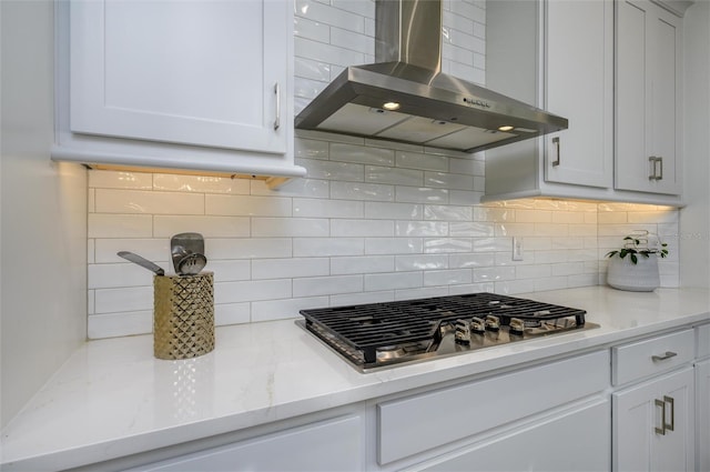 3952 Aldea Way, Wesley Chapel, FL 33543 - kitchen featuring wall chimney exhaust hood, stainless steel gas cooktop, backsplash, light stone counters, and white cabinetry