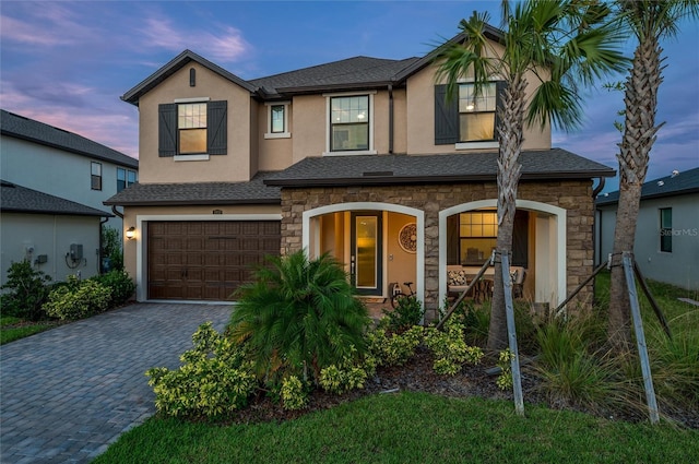 3952 Aldea Way, Wesley Chapel, FL 33543 - view of front facade featuring stone siding, a porch, an attached garage, and decorative driveway