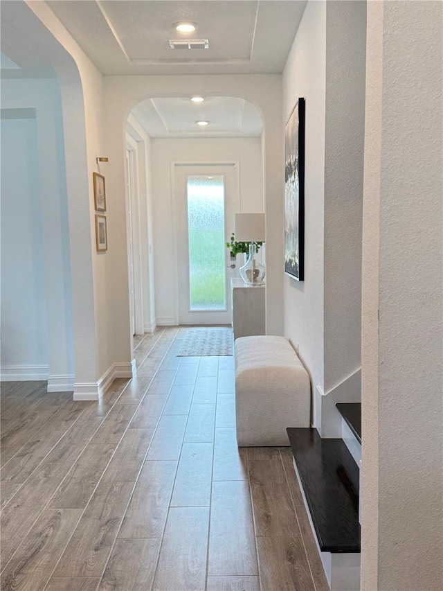 3952 Aldea Way, Wesley Chapel, FL 33543 - corridor featuring a tray ceiling, wood finished floors, and arched walkways