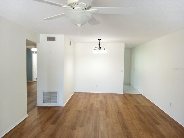2447 Ecuadorian Way Unit 11, Clearwater, FL 33763 - empty room with a ceiling fan, wood finished floors, baseboards, and a chandelier