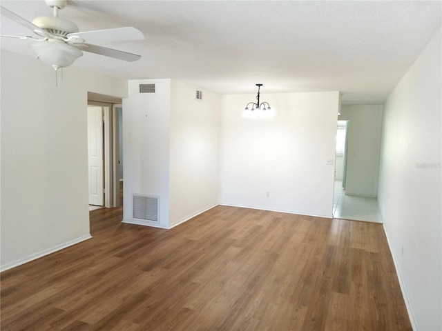 2447 Ecuadorian Way Unit 11, Clearwater, FL 33763 - unfurnished room with wood finished floors, a chandelier, ceiling fan, and baseboards
