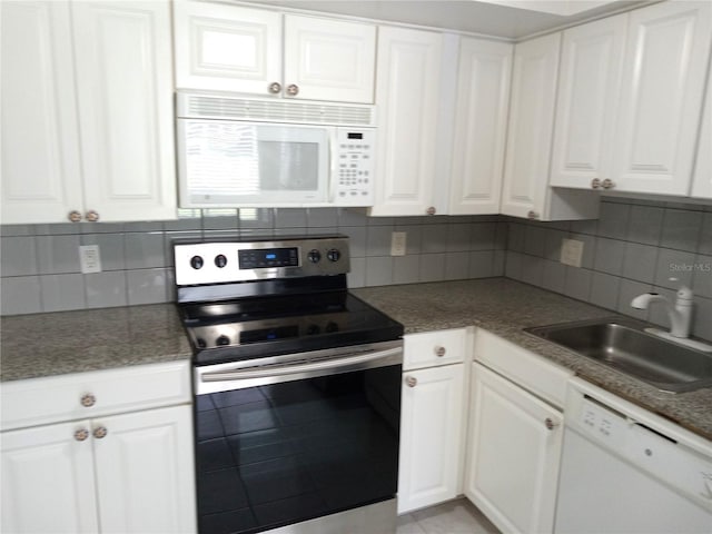 2447 Ecuadorian Way Unit 11, Clearwater, FL 33763 - kitchen with white appliances, a sink, white cabinets, and decorative backsplash