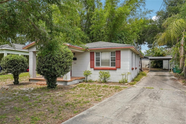 7511 N Ola Ave, Tampa, FL 33604 - view of front of house with concrete block siding, concrete driveway, and a shingled roof