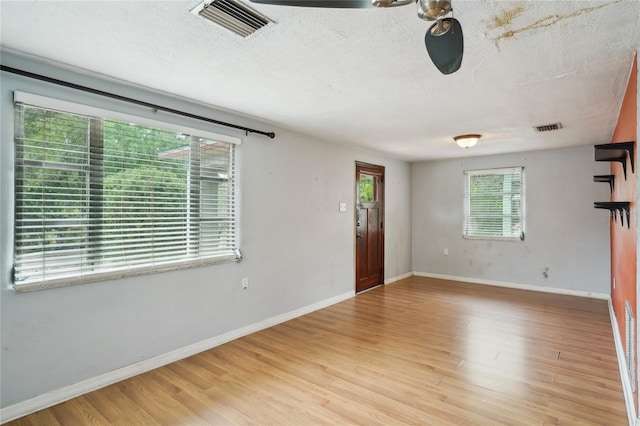 7511 N Ola Ave, Tampa, FL 33604 - unfurnished room featuring light wood-type flooring, a textured ceiling, and baseboards