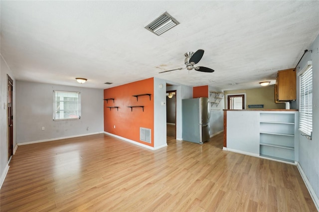 7511 N Ola Ave, Tampa, FL 33604 - unfurnished living room with ceiling fan, light wood finished floors, and baseboards