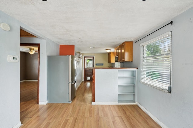 7511 N Ola Ave, Tampa, FL 33604 - kitchen with freestanding refrigerator, brown cabinetry, light wood-style flooring, and healthy amount of natural light