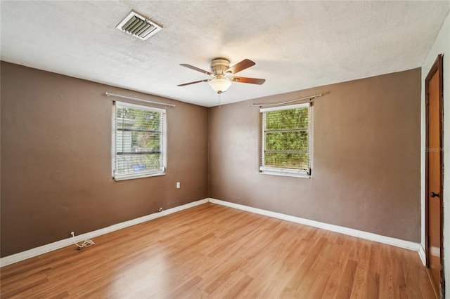7511 N Ola Ave, Tampa, FL 33604 - unfurnished room featuring healthy amount of natural light, light wood-style flooring, ceiling fan, baseboards, and a textured ceiling