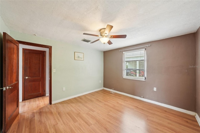 7511 N Ola Ave, Tampa, FL 33604 - empty room with light wood-type flooring, a textured ceiling, ceiling fan, and baseboards