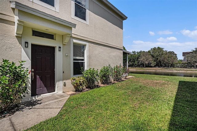 2542 Glenrise Pl, Wesley Chapel, FL 33544 - entrance to property featuring a lawn, stucco siding, and a water view