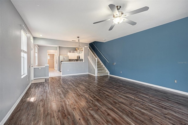 2542 Glenrise Pl, Wesley Chapel, FL 33544 - unfurnished living room featuring stairs, wood finished floors, baseboards, a chandelier, and a ceiling fan