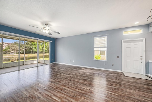 2542 Glenrise Pl, Wesley Chapel, FL 33544 - unfurnished living room featuring a ceiling fan, wood finished floors, and baseboards