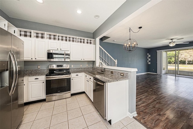 2542 Glenrise Pl, Wesley Chapel, FL 33544 - kitchen with appliances with stainless steel finishes, a sink, open floor plan, a peninsula, and white cabinets