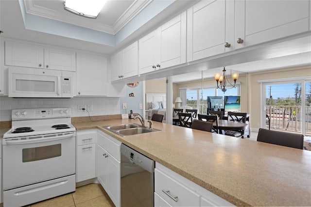 13440 Gulf Blvd Unit 202, Madeira Beach, FL 33708 - kitchen with white appliances, a sink, healthy amount of natural light, light countertops, and ornamental molding