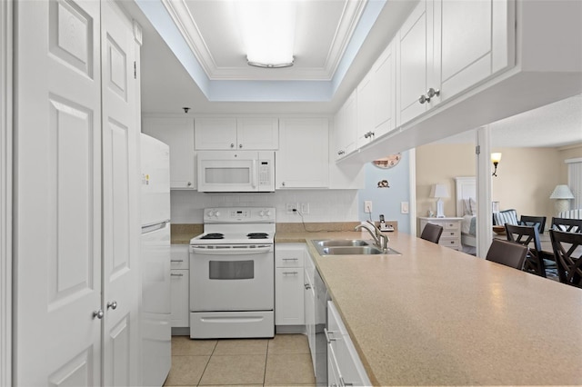 13440 Gulf Blvd Unit 202, Madeira Beach, FL 33708 - kitchen with white appliances, a sink, light tile patterned flooring, a raised ceiling, and white cabinetry