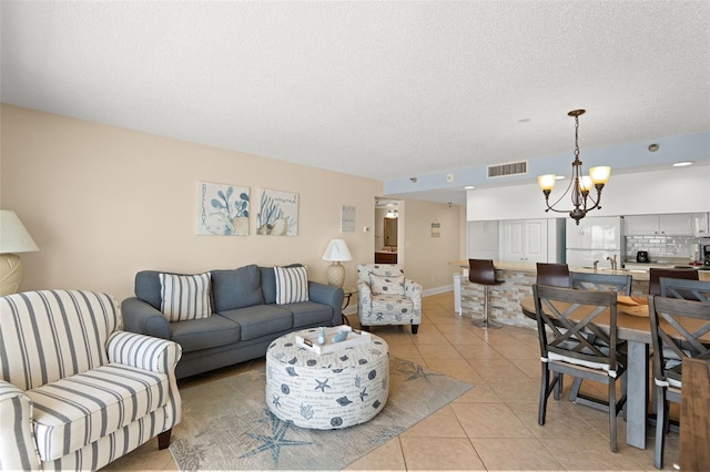 13440 Gulf Blvd Unit 202, Madeira Beach, FL 33708 - living room with a chandelier, light tile patterned floors, and a textured ceiling