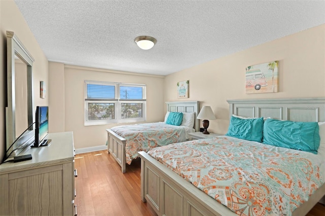 13440 Gulf Blvd Unit 202, Madeira Beach, FL 33708 - bedroom with light wood finished floors, a textured ceiling, and baseboards