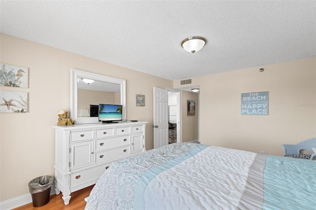 13440 Gulf Blvd Unit 202, Madeira Beach, FL 33708 - bedroom featuring wood finished floors and a textured ceiling