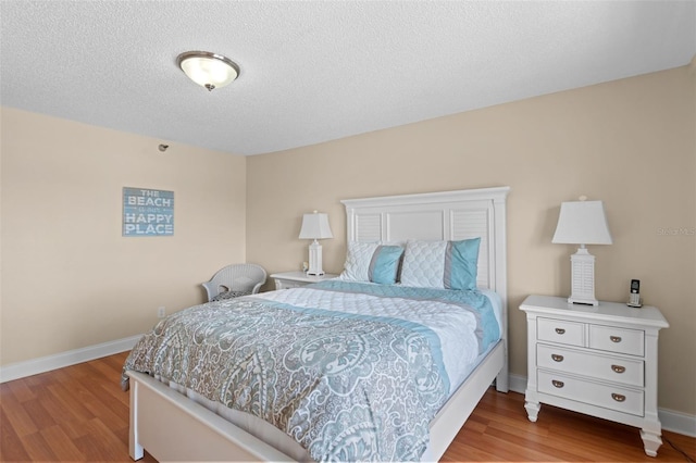 13440 Gulf Blvd Unit 202, Madeira Beach, FL 33708 - bedroom featuring wood finished floors, baseboards, and a textured ceiling