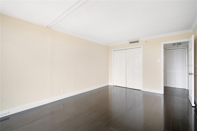 3211 W Swann Ave Unit 605, Tampa, FL 33609 - unfurnished bedroom featuring baseboards, a closet, ornamental molding, and dark wood-style flooring