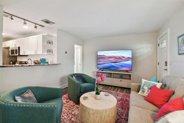4324 S Clark Ave, Tampa, FL 33611 - living area featuring wood finished floors, baseboards, and track lighting