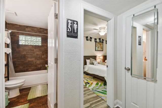 4324 S Clark Ave, Tampa, FL 33611 - full bathroom with wood finished floors, a ceiling fan, toilet, shower / bathtub combination with curtain, and connected bathroom