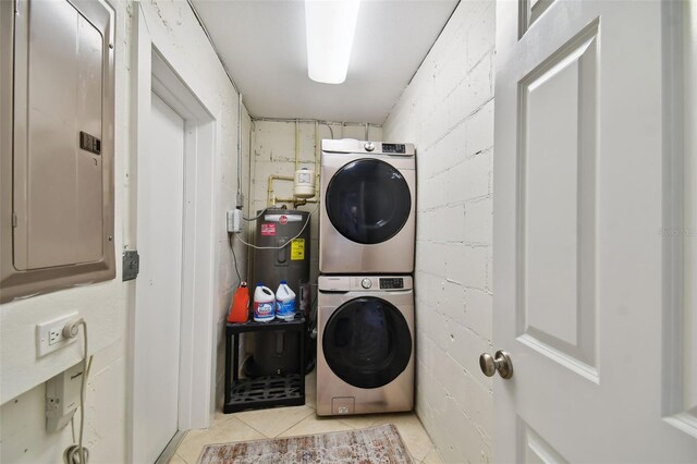 4324 S Clark Ave, Tampa, FL 33611 - laundry room featuring stacked washer / dryer, electric panel, light tile patterned floors, electric water heater, and concrete block wall