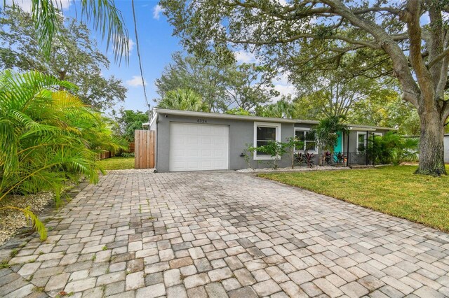 4324 S Clark Ave, Tampa, FL 33611 - view of front of property featuring stucco siding, decorative driveway, and a garage