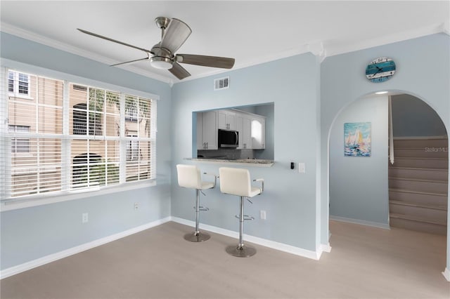 501 Knights Run Ave Unit 5103, Tampa, FL 33602 - dining room featuring ornamental molding, light wood-style floors, ceiling fan, arched walkways, and stairs