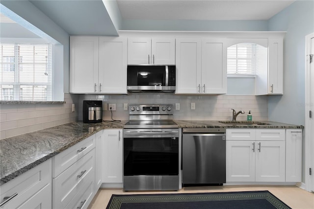 501 Knights Run Ave Unit 5103, Tampa, FL 33602 - kitchen featuring appliances with stainless steel finishes, a sink, white cabinetry, and tasteful backsplash