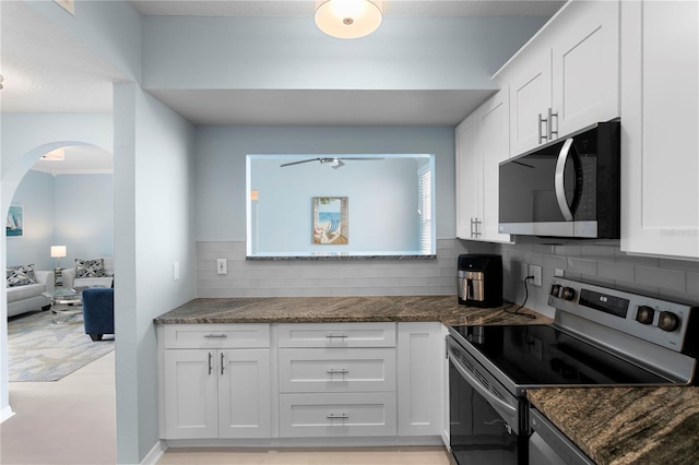 501 Knights Run Ave Unit 5103, Tampa, FL 33602 - kitchen with stainless steel range with electric cooktop, arched walkways, white cabinets, and backsplash