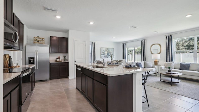 4401 Sand Dollar Way, Zephyrhills, FL 33541 - kitchen featuring appliances with stainless steel finishes, a sink, a breakfast bar area, open floor plan, and light tile patterned floors