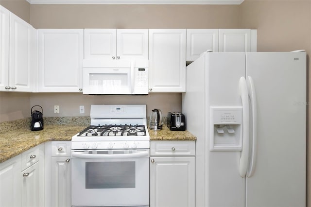 2705 Via Murano Unit 127, Clearwater, FL 33764 - kitchen with white appliances, white cabinetry, and light stone countertops