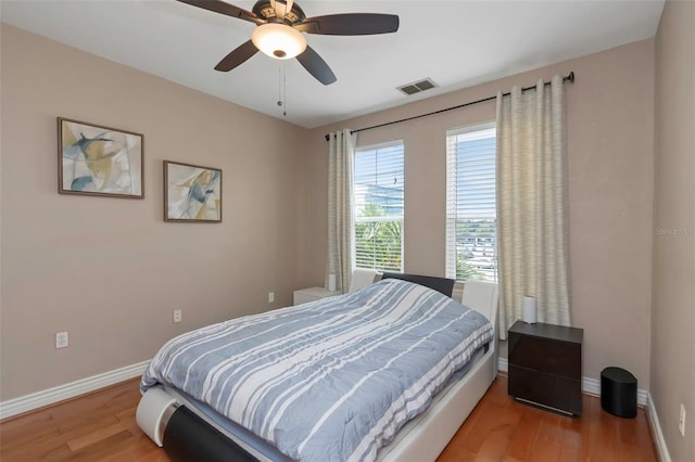 2705 Via Murano Unit 127, Clearwater, FL 33764 - bedroom featuring wood finished floors, baseboards, and a ceiling fan
