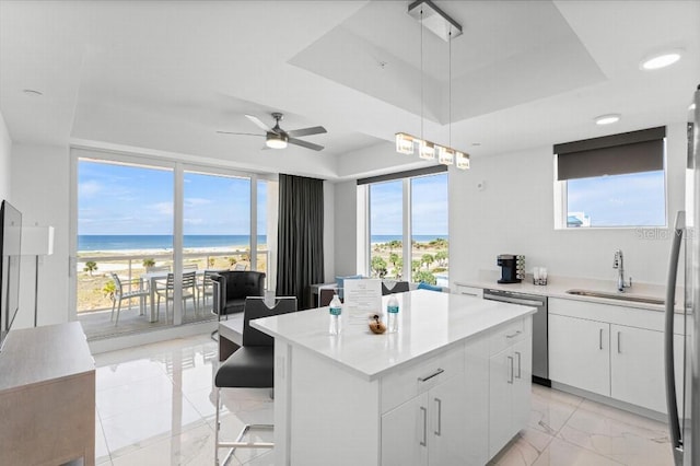 11500 Gulf Blvd Unit 513, Treasure Island, FL 33706 - kitchen featuring a sink, light marble finish flooring, stainless steel appliances, and a tray ceiling