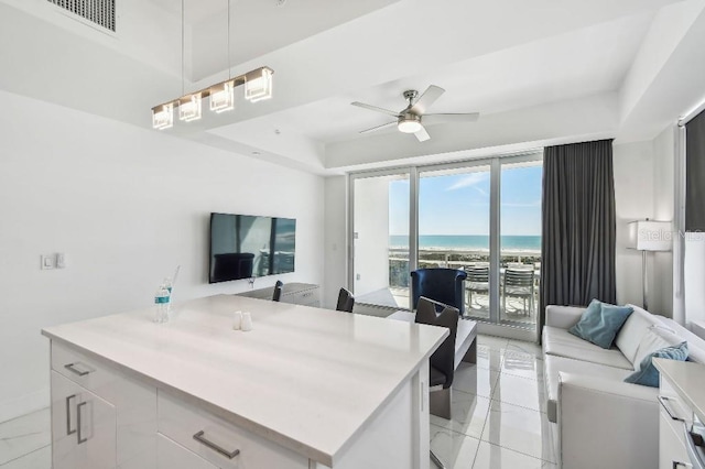 11500 Gulf Blvd Unit 513, Treasure Island, FL 33706 - kitchen featuring open floor plan, white cabinets, a ceiling fan, and light countertops