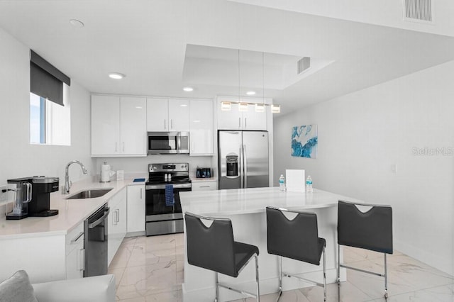 11500 Gulf Blvd Unit 513, Treasure Island, FL 33706 - kitchen with stainless steel appliances, a sink, light marble finish flooring, recessed lighting, and a breakfast bar area