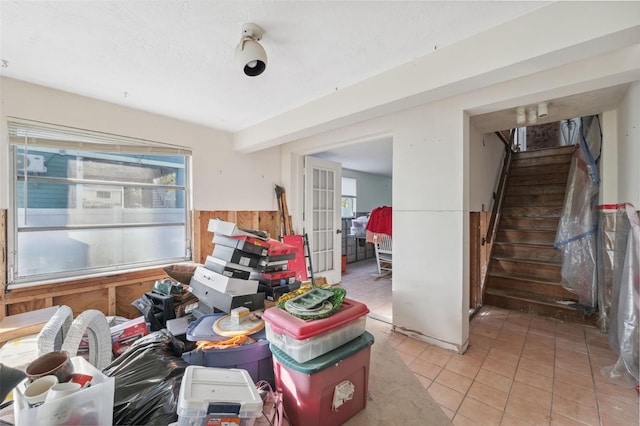 108 Shore Dr, Tarpon Springs, FL 34689 - living area featuring stairs, wooden walls, light tile patterned floors, and wainscoting