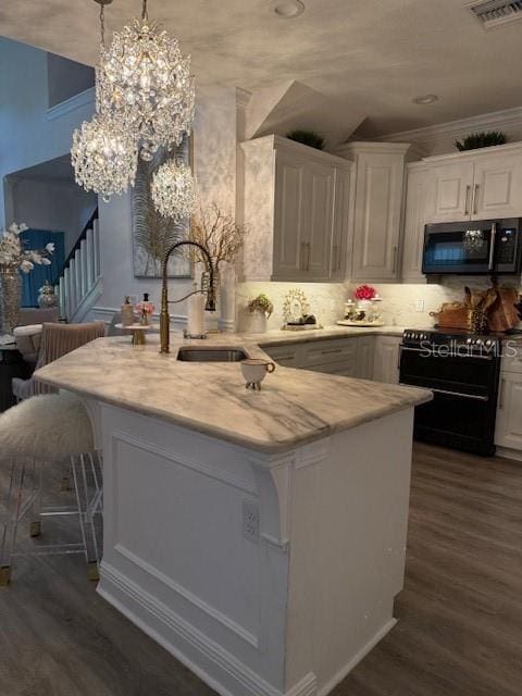 5332 Riverwalk Preserve Dr, New Port Richey, FL 34653 - kitchen featuring range with two ovens, a sink, white cabinetry, dark wood-style floors, and ornamental molding