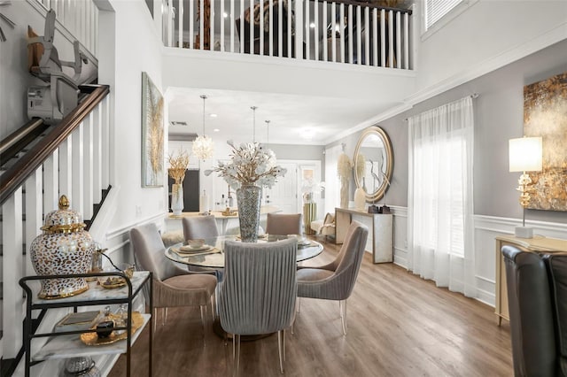 5332 Riverwalk Preserve Dr, New Port Richey, FL 34653 - dining space with a towering ceiling, wood finished floors, a decorative wall, ornamental molding, and stairway