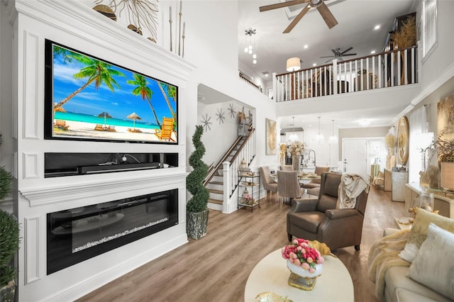 5332 Riverwalk Preserve Dr, New Port Richey, FL 34653 - living room featuring a high ceiling, stairs, ceiling fan, wood finished floors, and recessed lighting