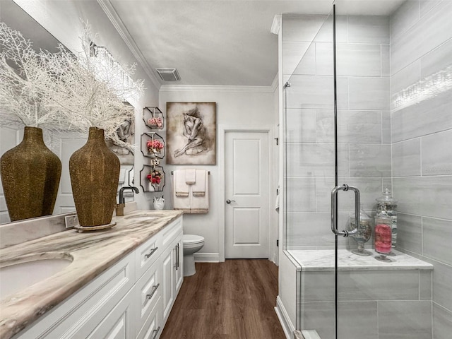 5332 Riverwalk Preserve Dr, New Port Richey, FL 34653 - bathroom with wood finished floors, a shower stall, crown molding, double vanity, and toilet