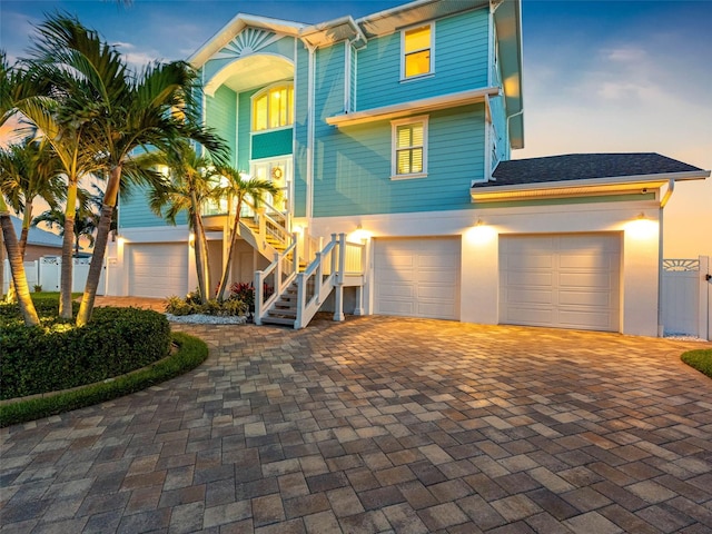11000 8th St E, Treasure Island, FL 33706 - beach home with stairs, decorative driveway, and an attached garage