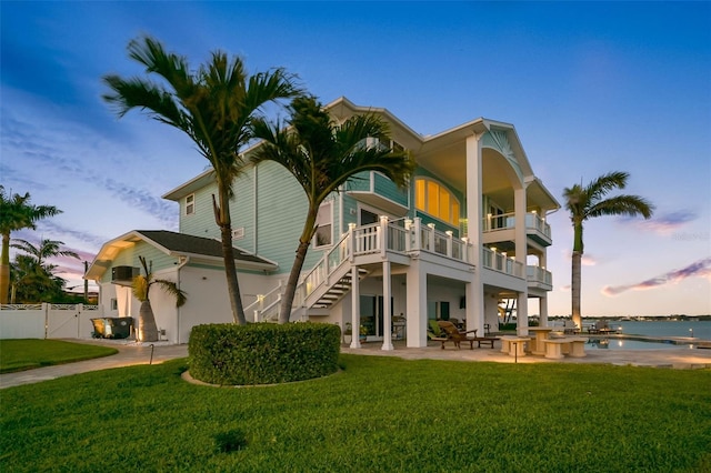 11000 8th St E, Treasure Island, FL 33706 - back of house with a patio area, a balcony, stucco siding, stairway, and a water view