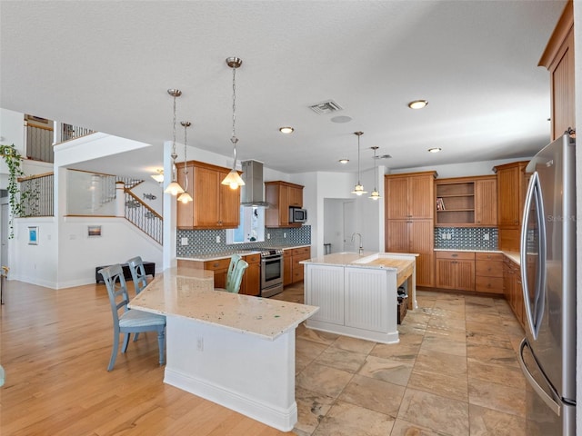 11000 8th St E, Treasure Island, FL 33706 - kitchen with appliances with stainless steel finishes, open shelves, brown cabinetry, tasteful backsplash, and recessed lighting