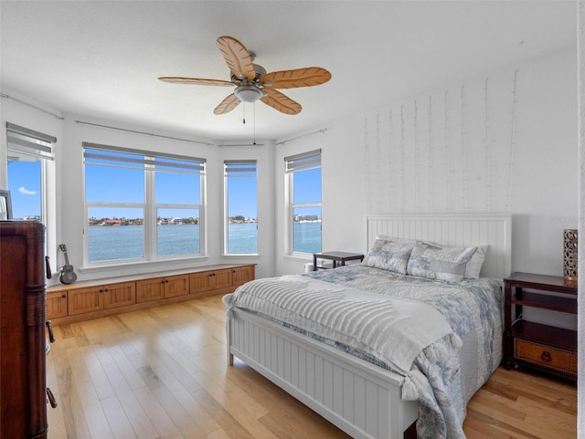 11000 8th St E, Treasure Island, FL 33706 - bedroom featuring light wood-style floors, a water view, and a ceiling fan